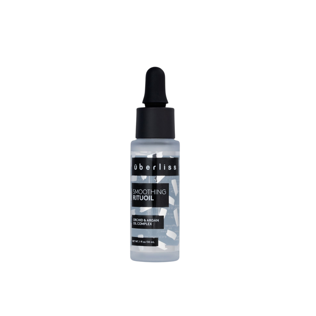 A bottle of Uberliss RituOil, which is a hair treatment product containing Argan Oil, designed to quench hair's thirst and enhance softness and shine.