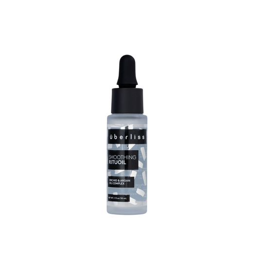 A bottle of Uberliss RituOil, which is a hair treatment product containing Argan Oil, designed to quench hair's thirst and enhance softness and shine.